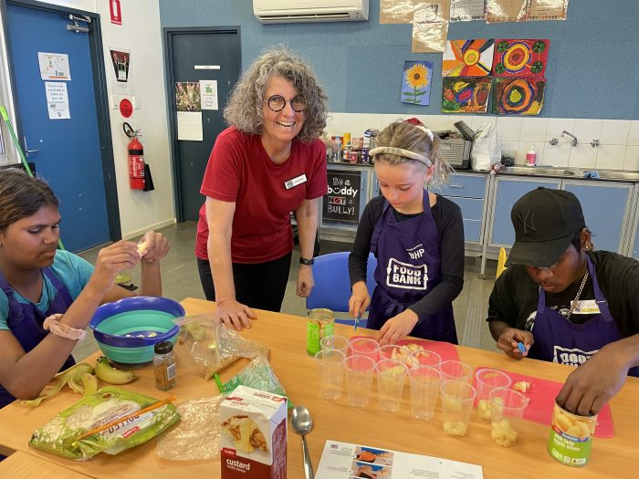 professor pollard guiding the kids in preparing food