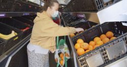 a woman wearing facemask in fruit section