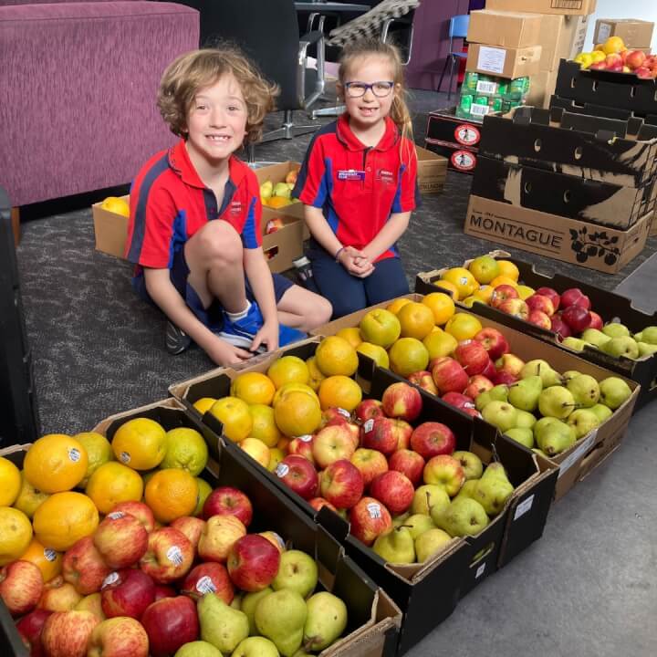 Two Horsham students with boxes of fruit