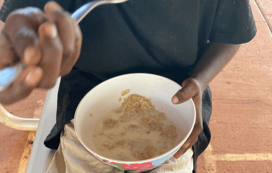 a kid holding a bowl of cereal