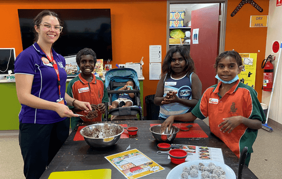 Foodbank WA volunteer guiding kimberley students in cooking