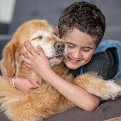 Young boy hugging dog