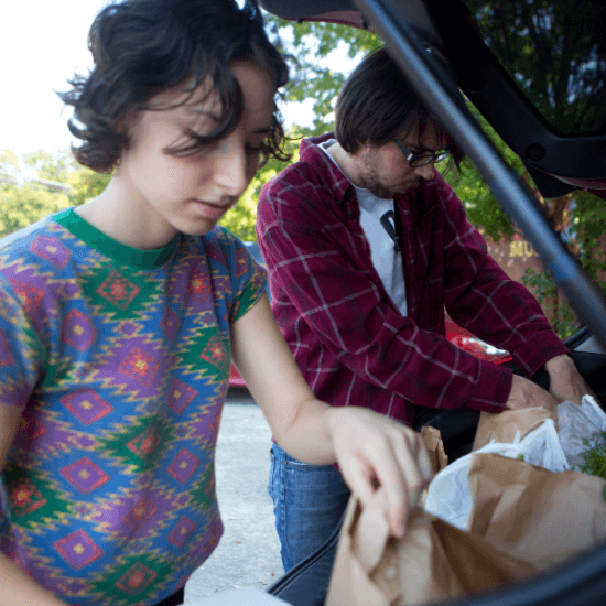 Young people unloading groceries from car