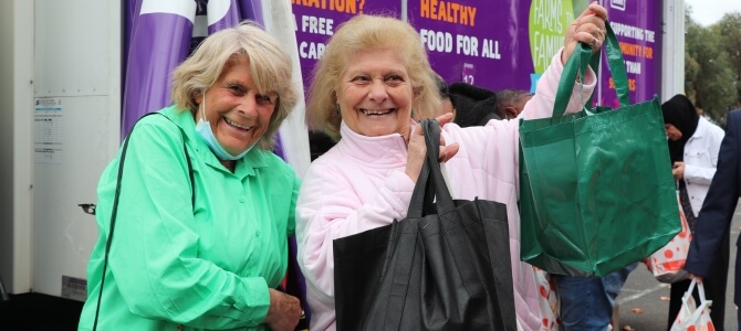 Women holding up shopping bag after visiting a Foodbank